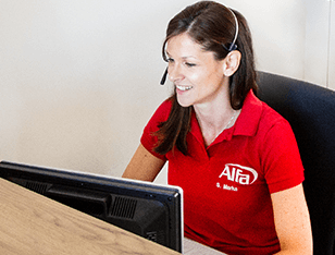 frau vor zwei monitoren mit headset und alfa shirt